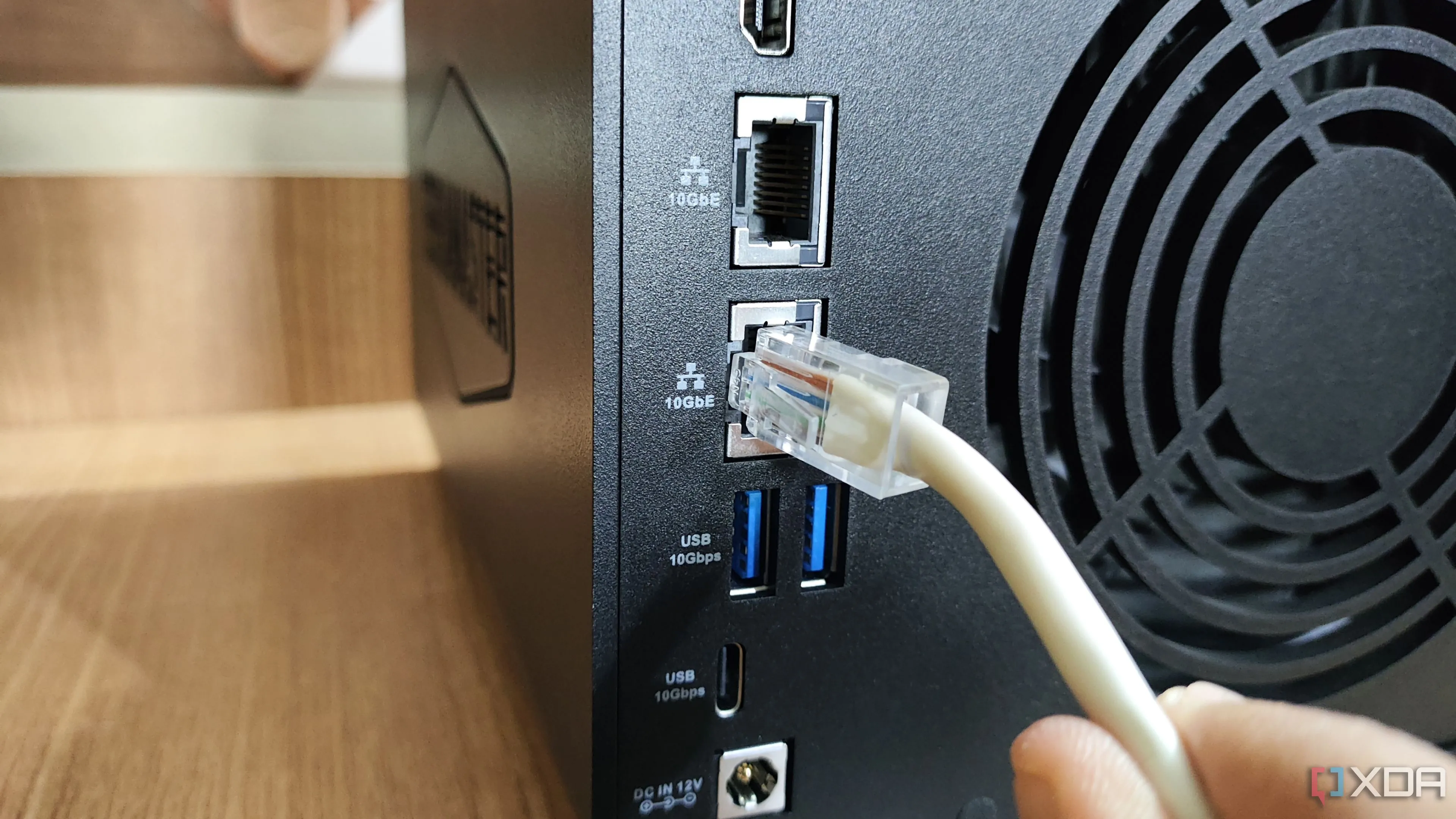 Cắm cáp Ethernet vào cổng LAN 10GbE trên NAS TerraMaster F4-424 Max, liên quan đến kết nối mạng và hiệu quả hoạt động