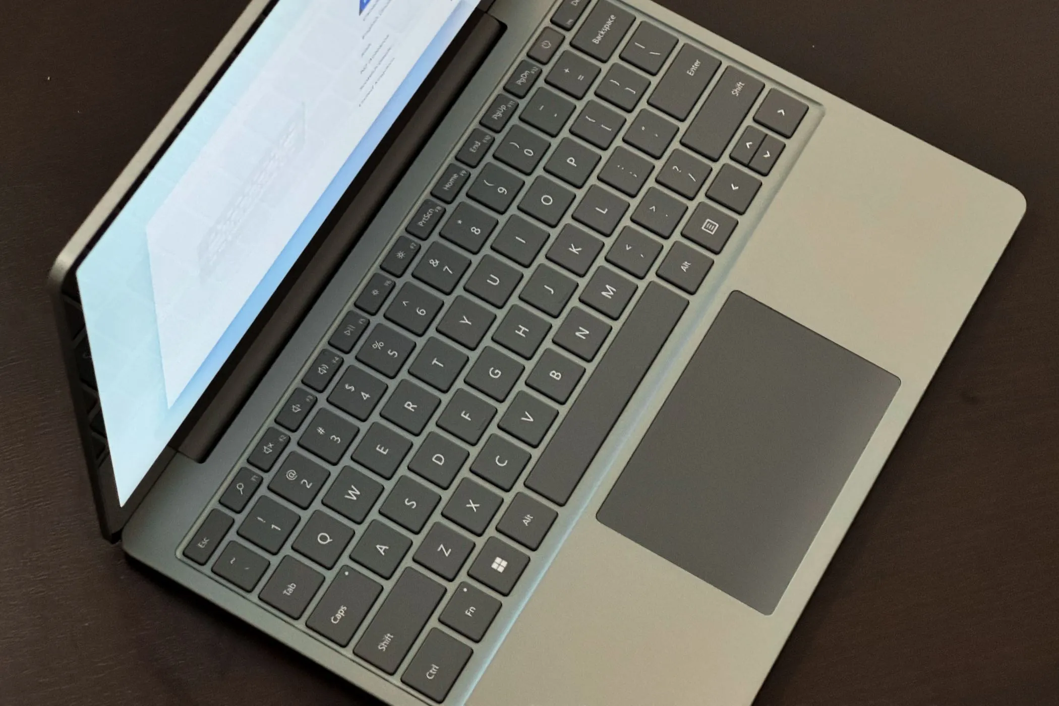 Cận cảnh bàn phím và trackpad của Surface Laptop Go 3, minh họa thiết kế thường bị ảnh hưởng trên các mẫu laptop mỏng nhẹ.
