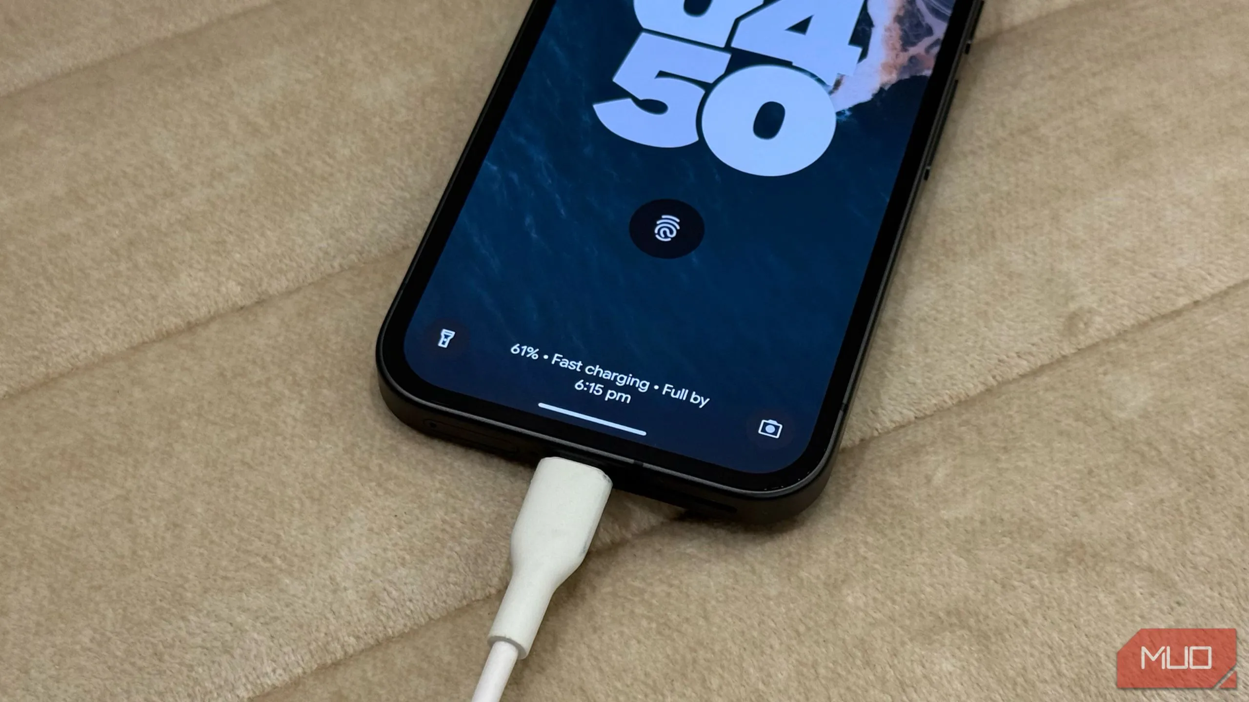 Điện thoại Google Pixel 9a đang sạc nhanh trên ghế sofa màu trắng, minh họa việc sử dụng thiết bị khi sạc.