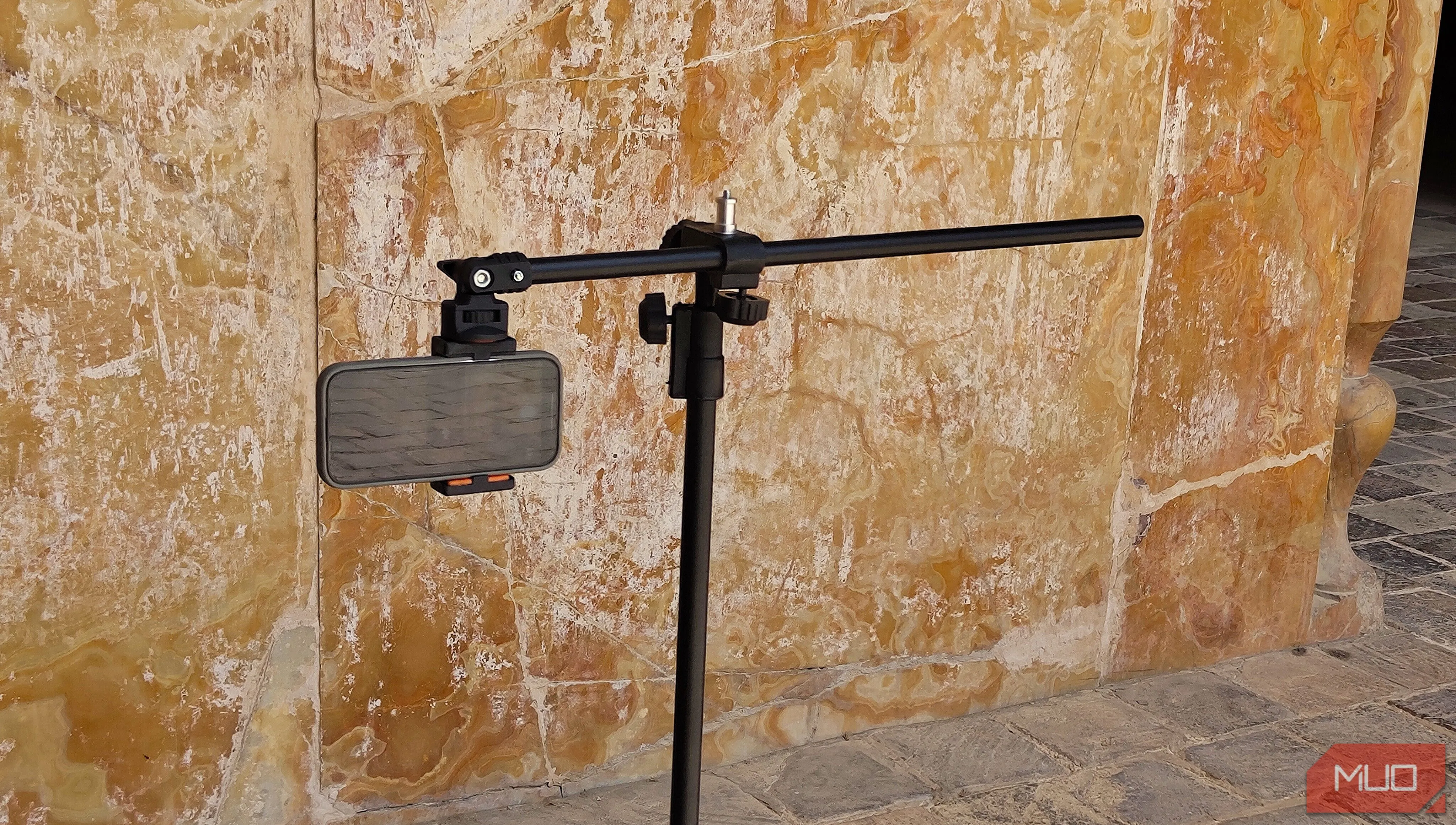 alt text mô tả điện thoại gắn trên tripod đang hướng vào một bức tường để chụp ảnh