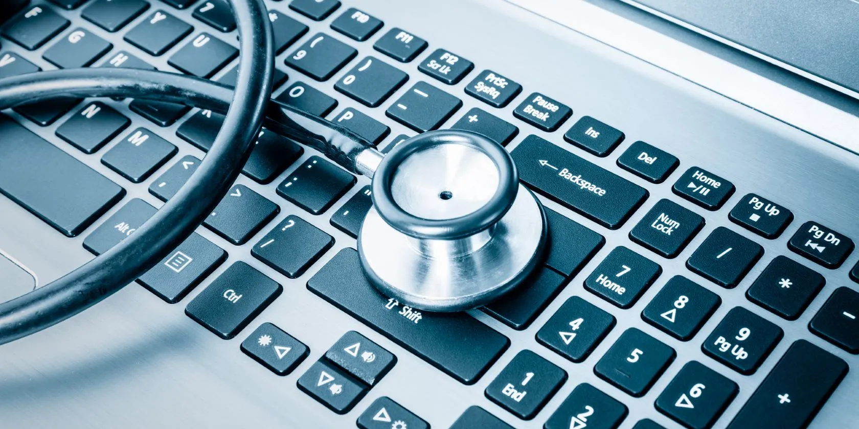 Bàn phím laptop với ống nghe đặt trên, biểu tượng cho việc chẩn đoán và khắc phục vấn đề hiệu suất máy tính, có thể do virus.