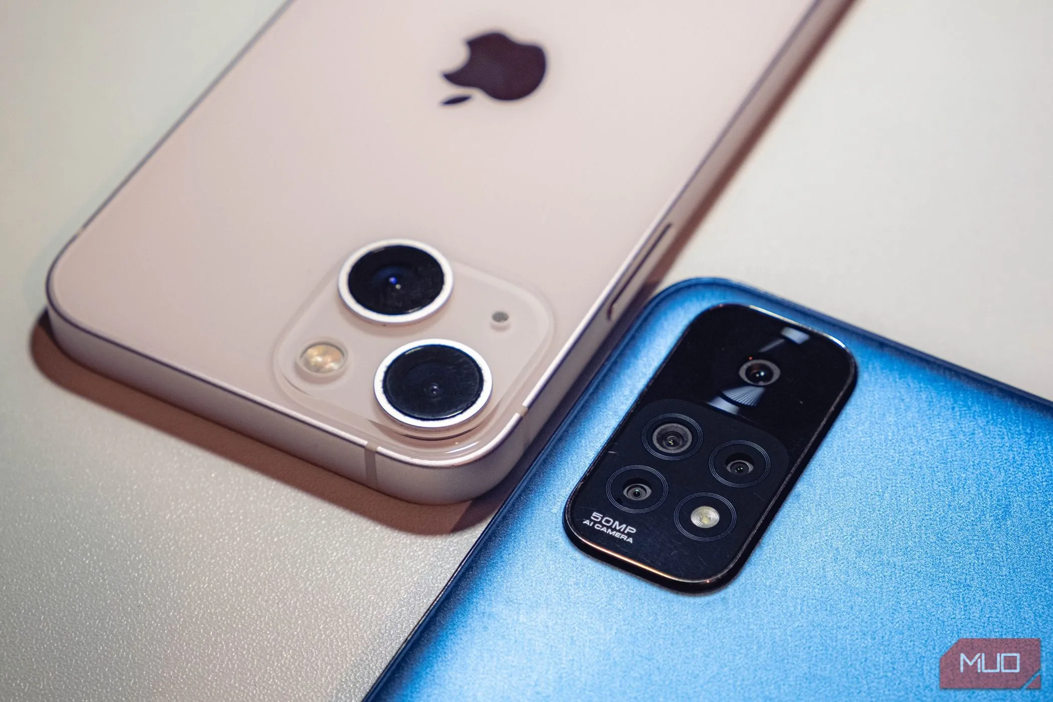 Hai chiếc smartphone tầm trung màu xanh và hồng đặt úp mặt, tượng trưng cho sự đa dạng và giá trị của phân khúc này