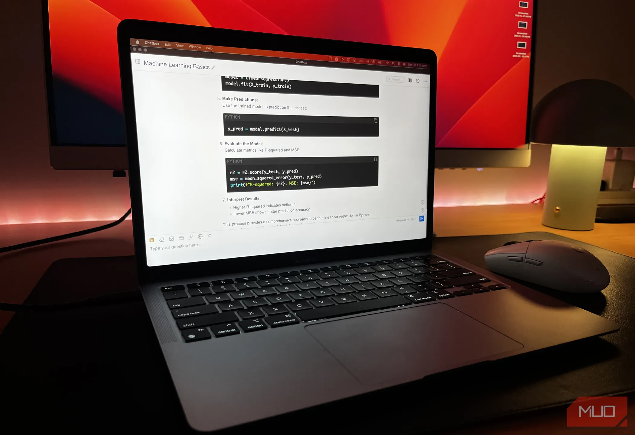 Hình ảnh một máy MacBook đang chạy mô hình DeepSeek-R1 cục bộ, phía sau là màn hình máy tính.