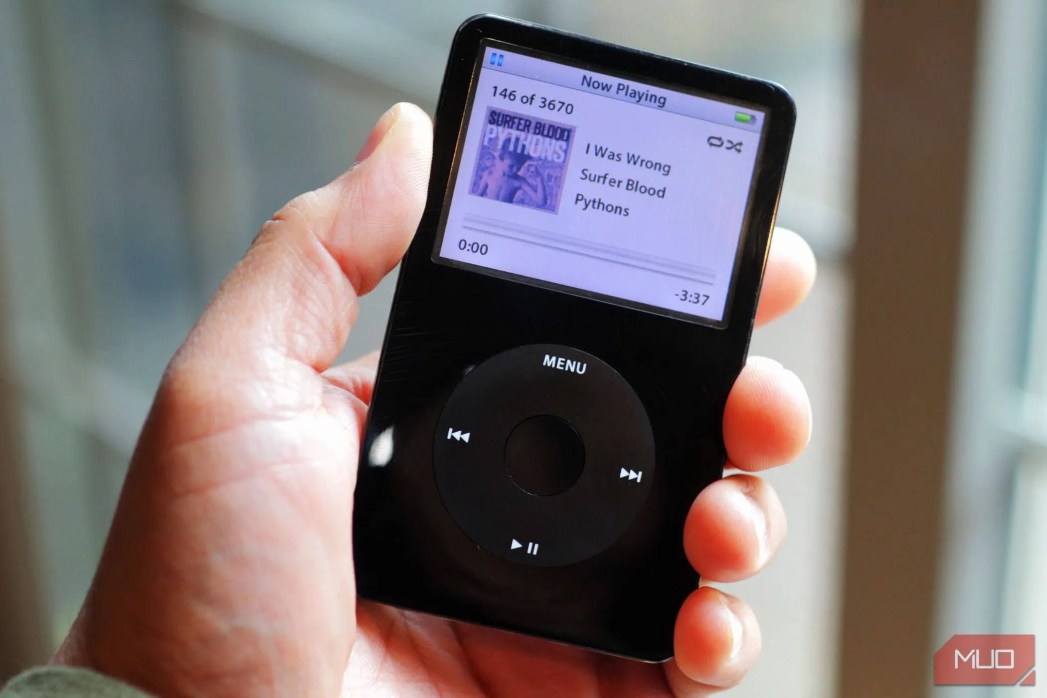 iPod Classic màu đen được cầm trên tay gần cửa sổ, thể hiện thiết bị nghe nhạc đã bị smartphone thay thế