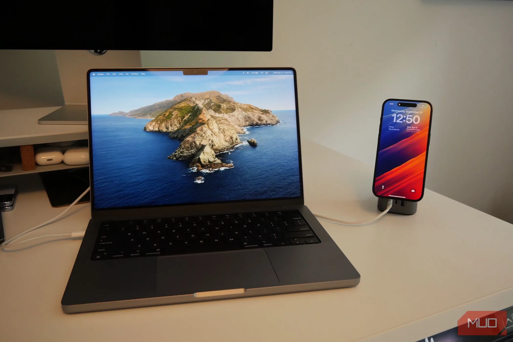 MacBook Pro và iPhone đang sạc trên bàn, gợi ý kết nối âm thanh không dây