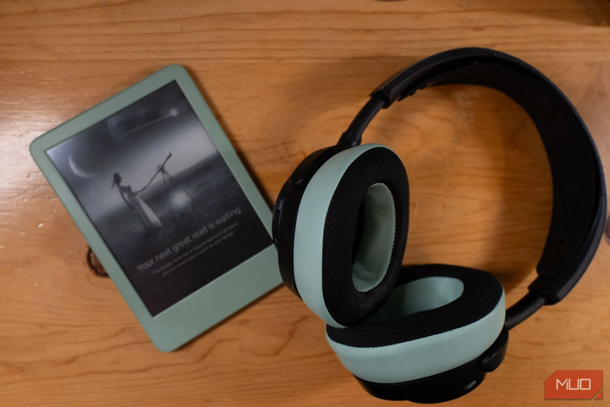 Máy đọc sách Kindle 2024 màu xanh Matcha với tai nghe cùng màu đặt cạnh