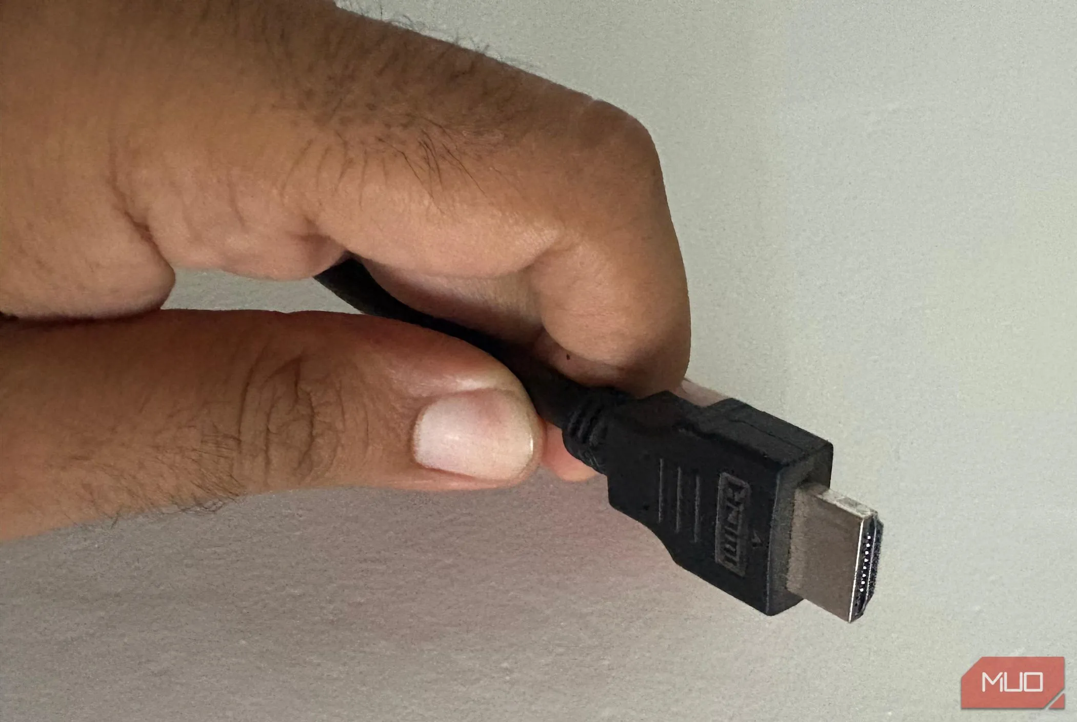 Một người đàn ông đang kiểm tra cáp HDMI, nhấn mạnh tầm quan trọng của việc lựa chọn đúng loại cáp cho trải nghiệm HDR tối ưu.