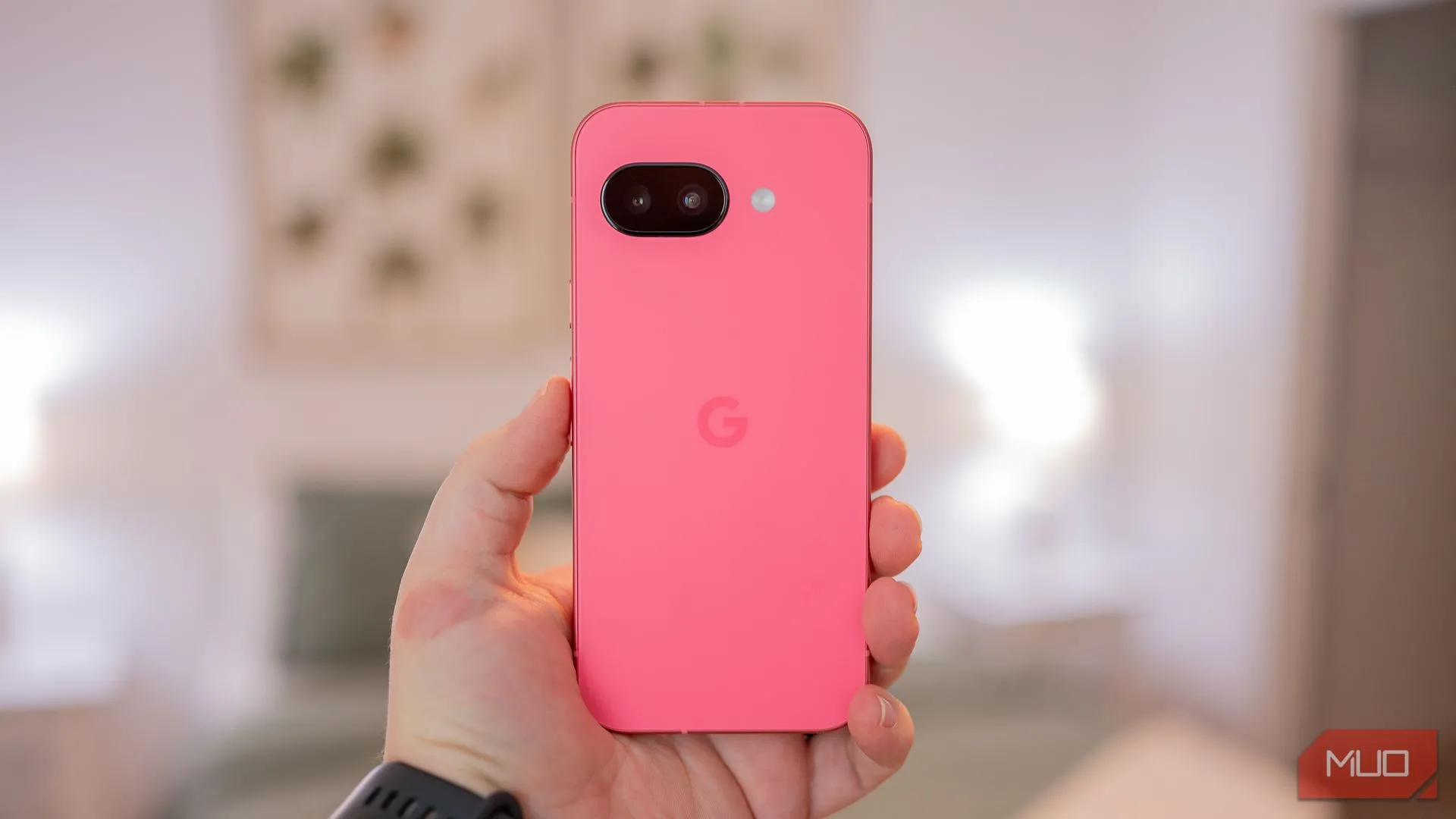 Một người đang cầm điện thoại Google Pixel 9a màu tím (Iris) trên tay, tập trung vào mặt lưng với thiết kế tối giản, chất liệu cao cấp và hệ thống camera tinh gọn.