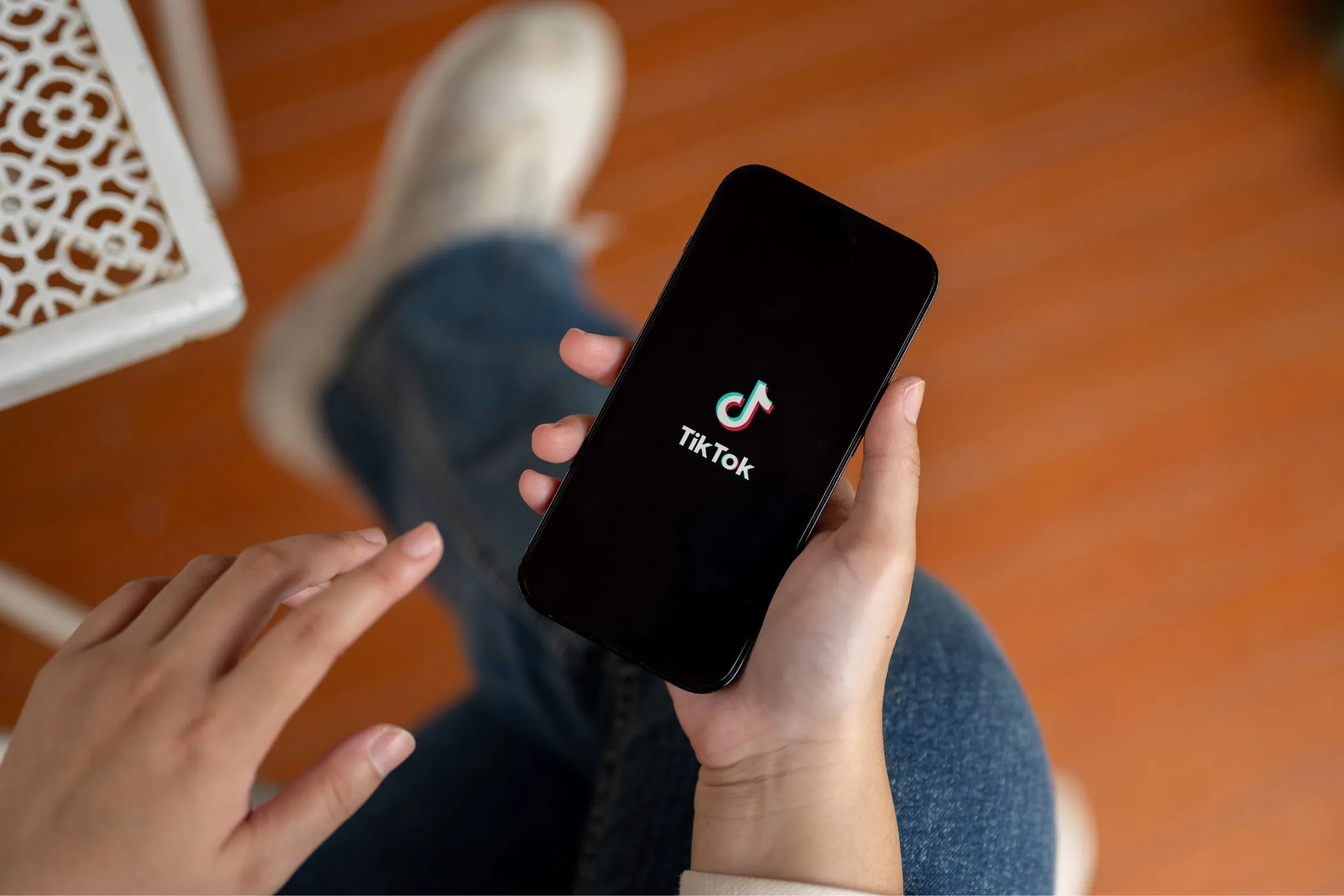 Một người đang cầm điện thoại hiển thị ứng dụng TikTok trên màn hình