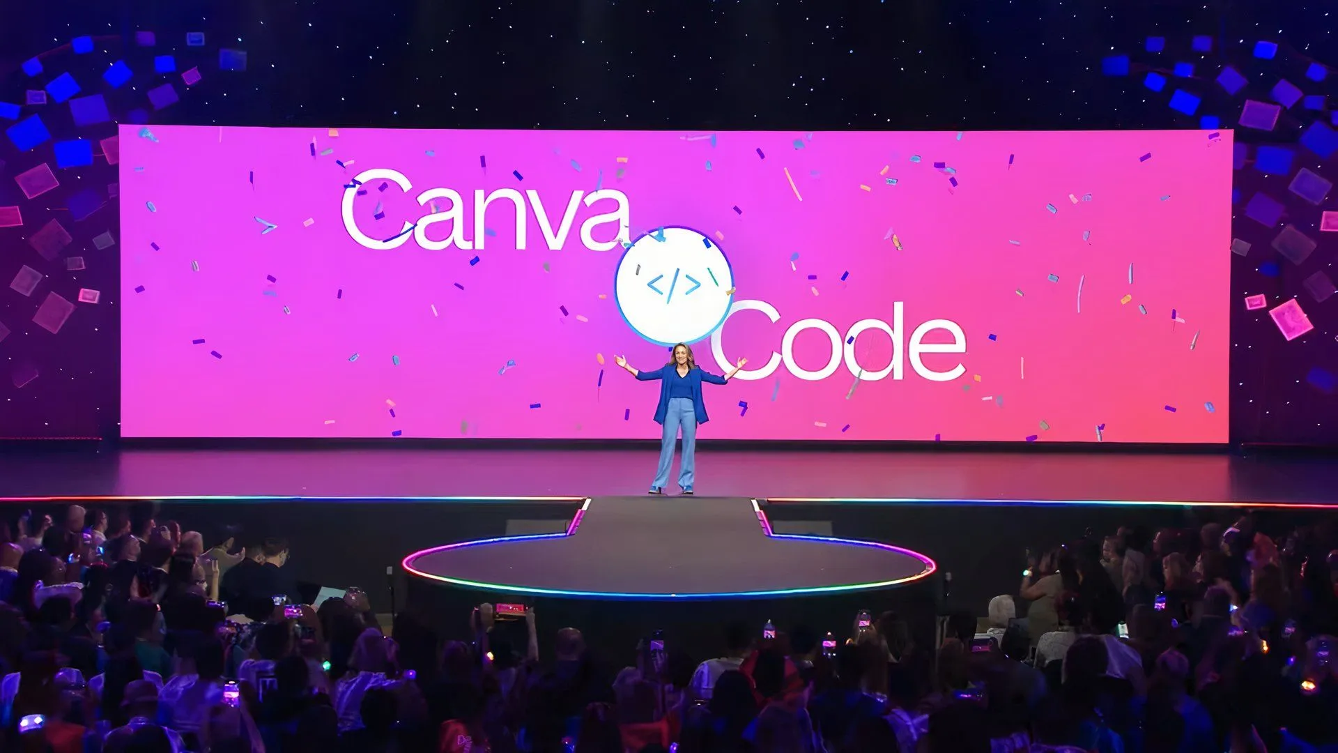 Một vài người thuyết trình trên sân khấu đang giới thiệu tính năng Canva Code mới trên màn hình lớn phía sau