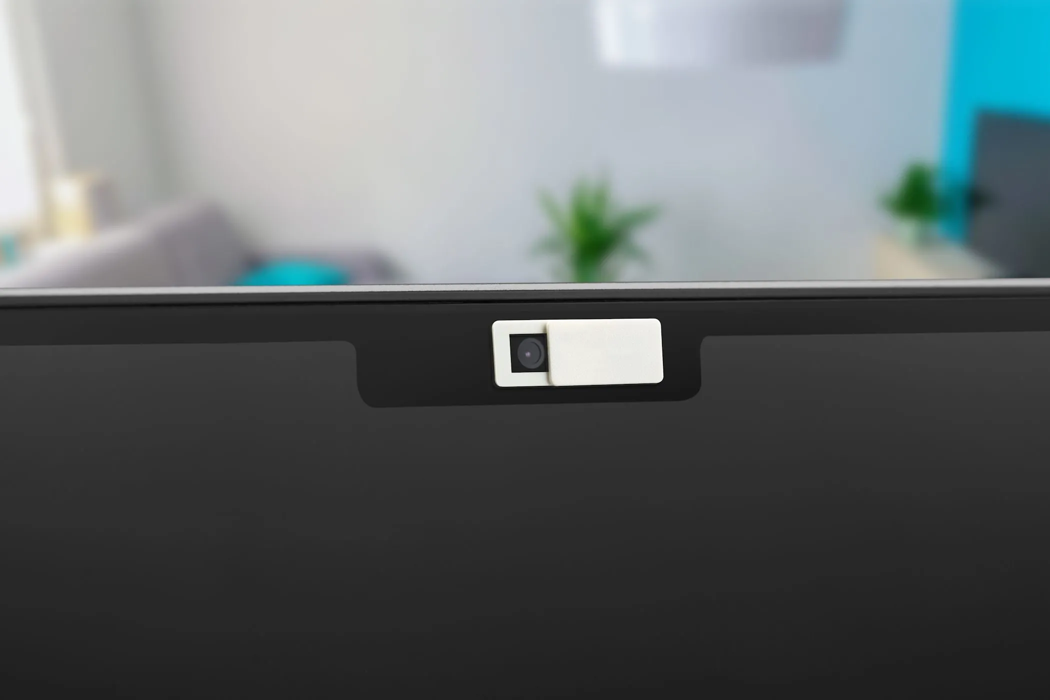 Nắp che webcam được đặt trên camera của một chiếc MacBook Air, thể hiện cách che ống kính để bảo vệ quyền riêng tư cá nhân.