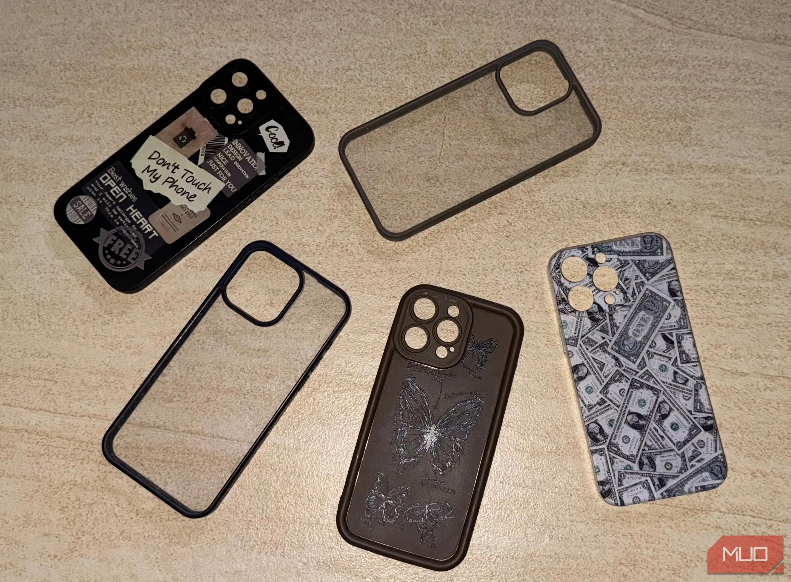 Nhiều ốp lưng điện thoại iPhone 15 Pro Max trên sàn nhà, minh họa cách ốp lưng có thể tăng thêm độ dày cho điện thoại.