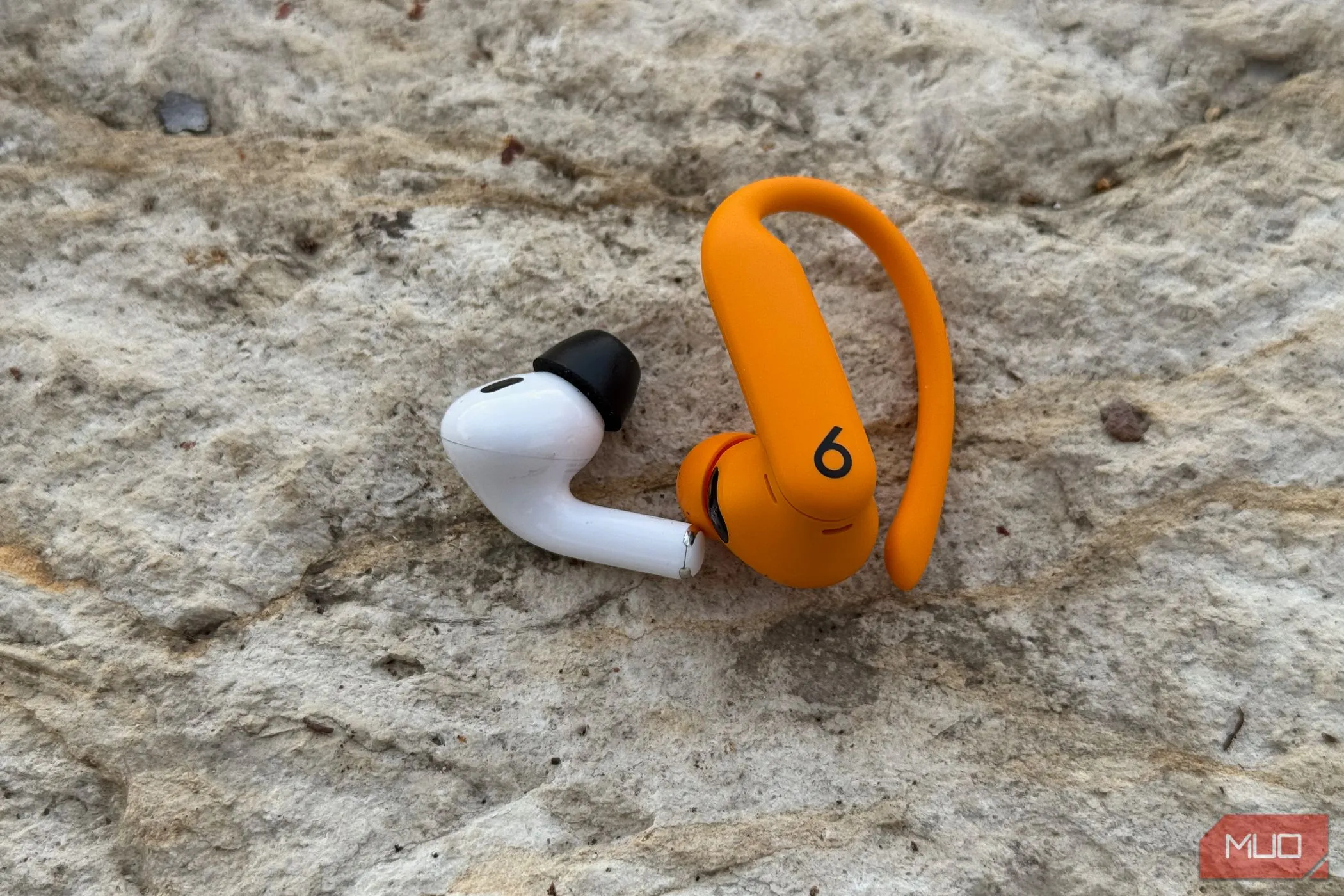 So sánh trọng lượng và thiết kế giữa tai nghe AirPods Pro 2 và Powerbeats Pro 2.