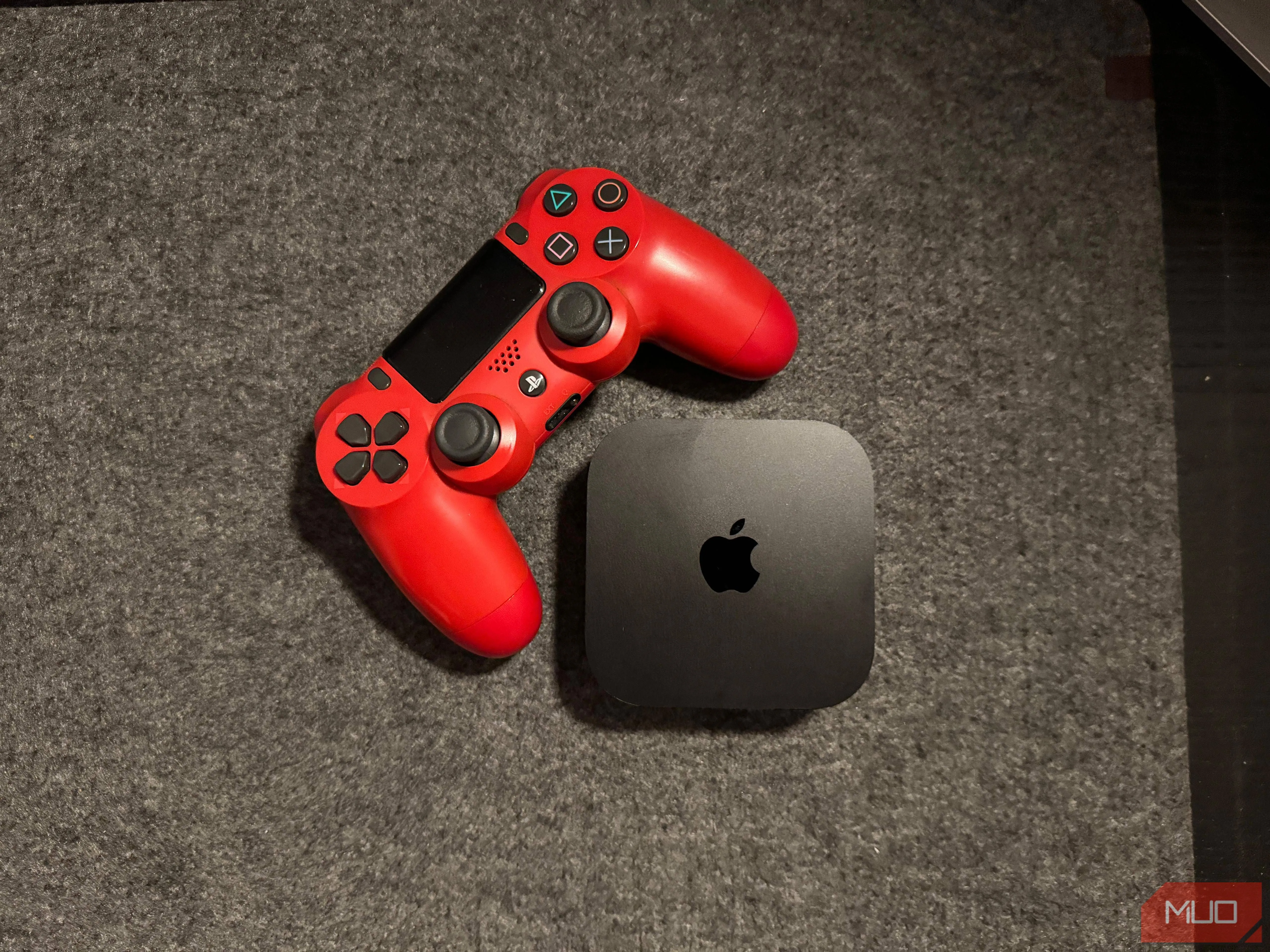 Thiết bị Apple TV 4K đặt cạnh bộ điều khiển PlayStation 4, minh họa khả năng chơi game nhẹ với chip A15 Bionic.