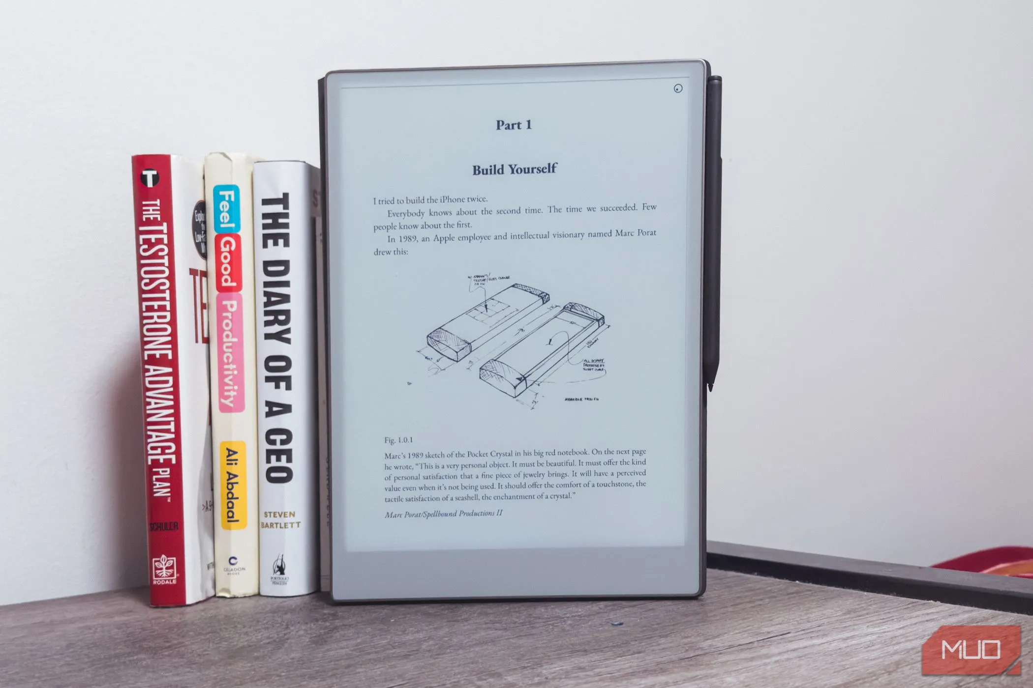 Thiết bị ghi chú reMarkable Paper Pro đặt cạnh những cuốn sách trên bàn gỗ, nhấn mạnh kích thước lớn hơn của máy.