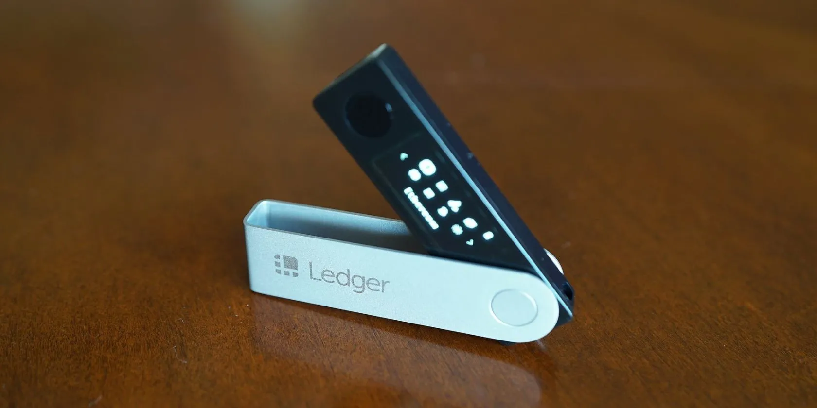 Ví lạnh Ledger Nano X trên bề mặt gỗ, biểu tượng của sự bảo mật cho tiền điện tử.